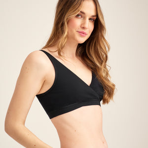 Modell trägt ooia Moms Still-BH in Schwarz – Still-BH ersetzt Stilleinlagen mit praktischer Pull-Down Funktion.