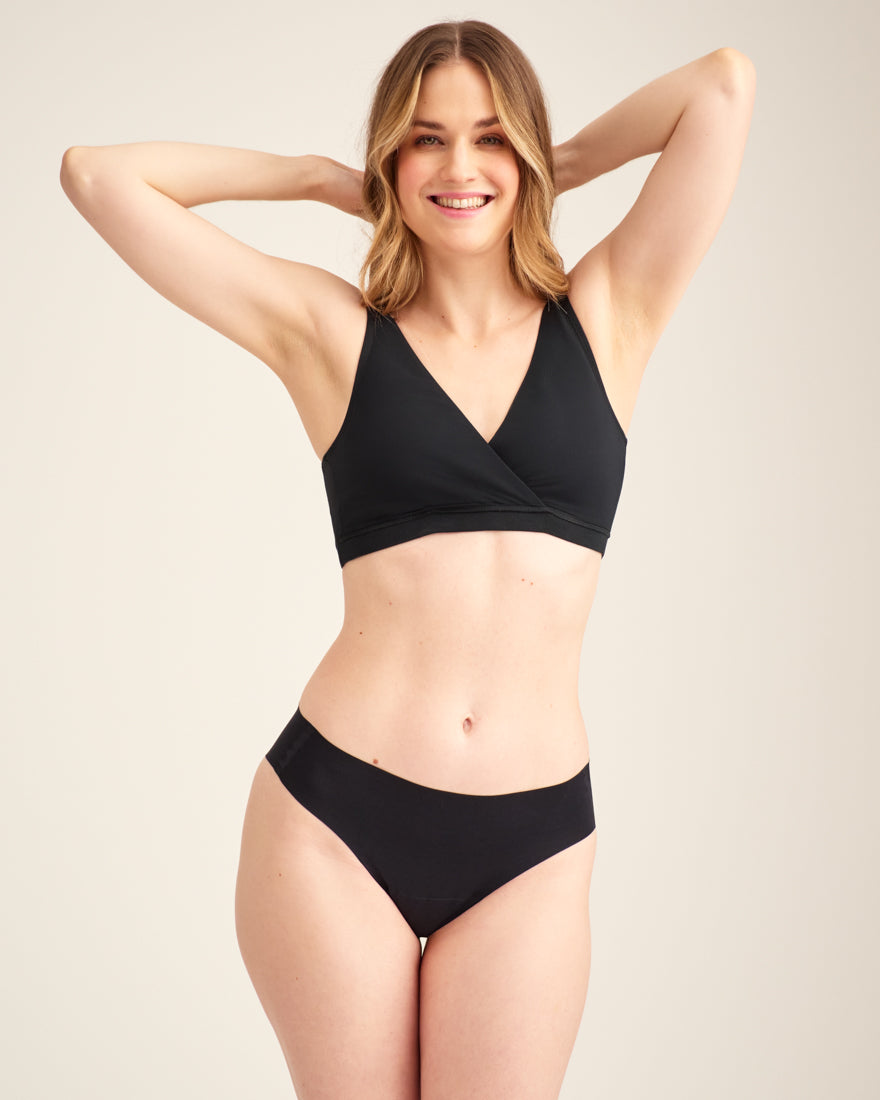 Modell trägt ooia Moms Still-BH in Schwarz – Still-BH ersetzt Stilleinlagen mit praktischer Pull-Down Funktion.