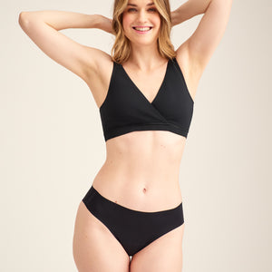 Modell trägt ooia Moms Still-BH in Schwarz – Still-BH ersetzt Stilleinlagen mit praktischer Pull-Down Funktion.