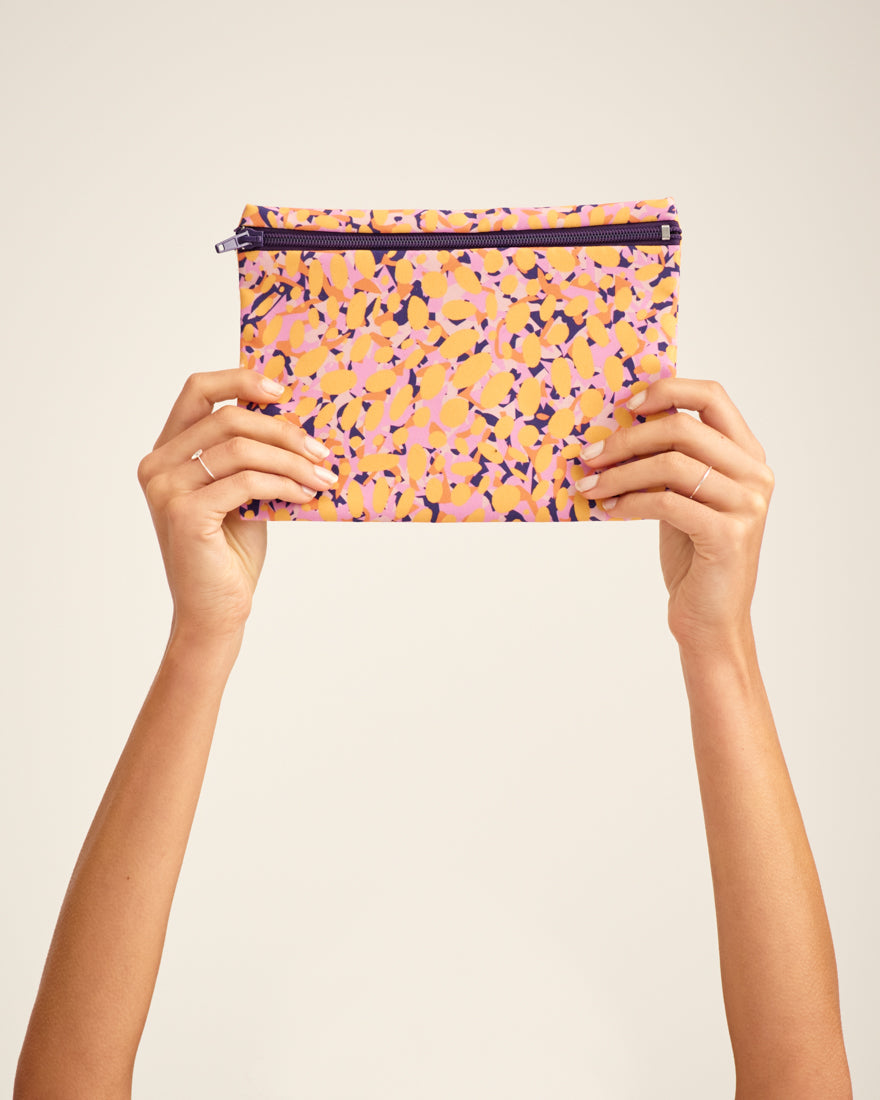 Modell hält die ooia Wetbag Edition 22/23, mit herbstlichen Aufdruck und flüssigkeitsundurchlässigem Innenstoff.