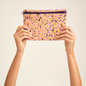 Modell hält die ooia Wetbag Edition 22/23, mit herbstlichen Aufdruck und flüssigkeitsundurchlässigem Innenstoff.