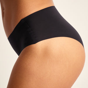 Modell trägt ooia Hipster Seamless in Schwarz – nahtlose Periodenunterwäsche.