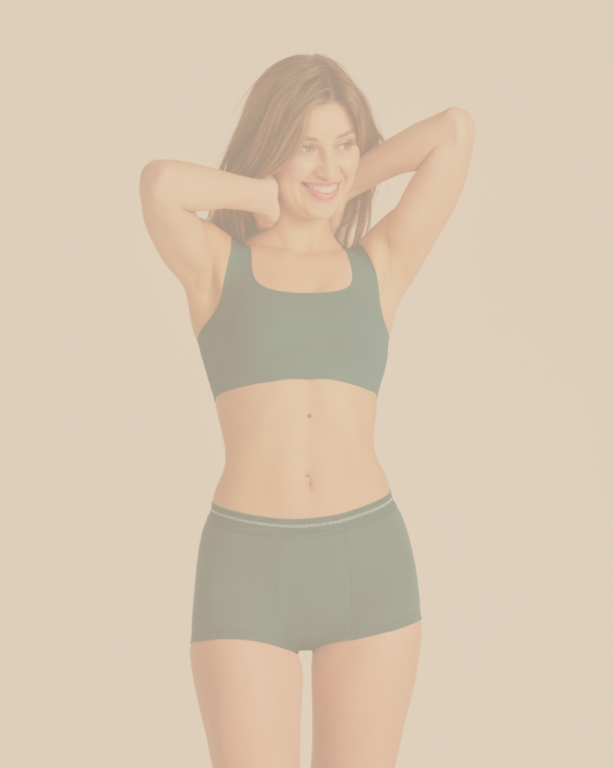 Eine Frau, die die Periodenunterwäsche Shorty Extra Strong in grün von ooia trägt