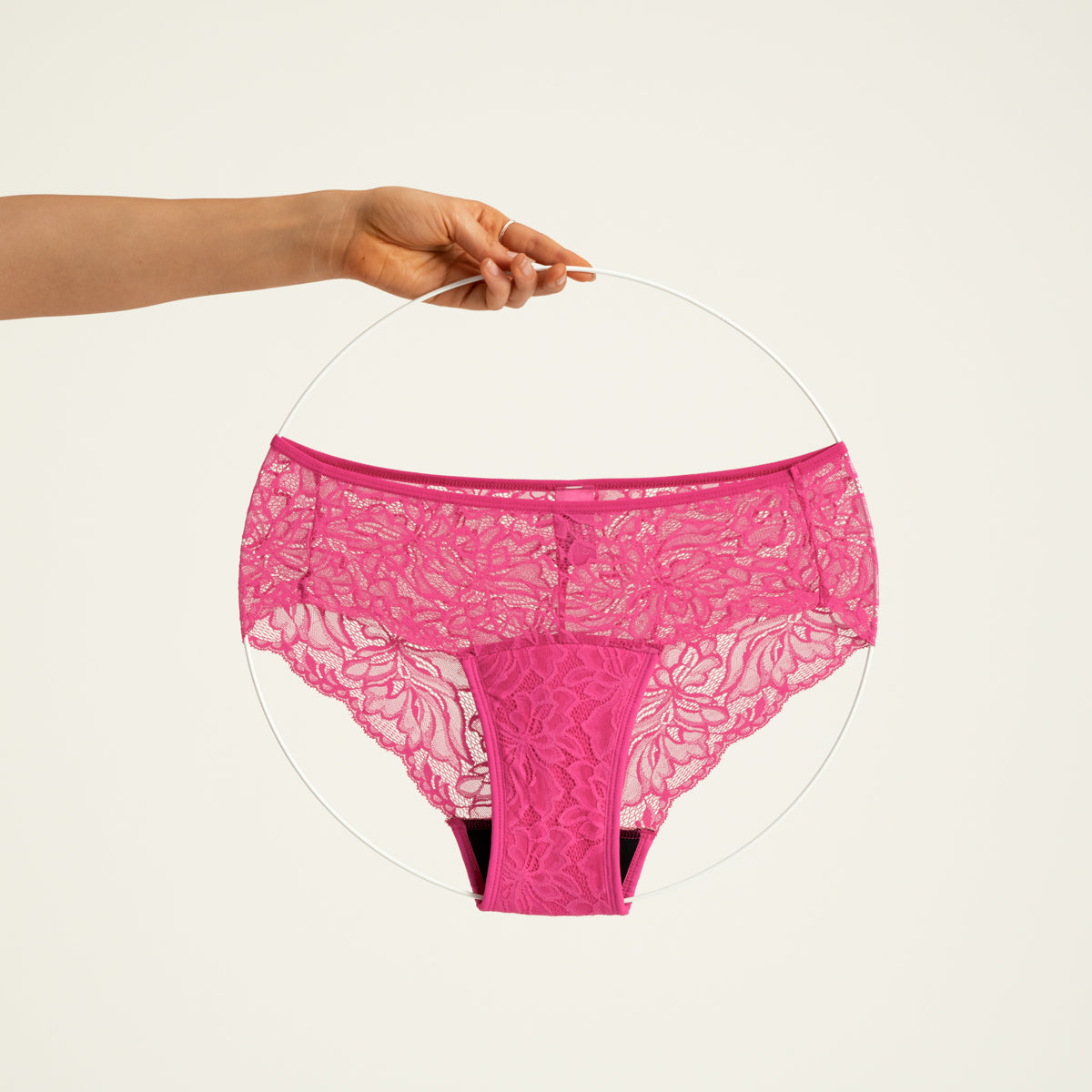 Modell trägt ooia Hipster Allover Lace in Hot Pink – Periodenslip mit durchgehender floraler Spitze. Freisteller.