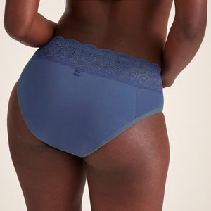 Modell trägt ooia Slip Extra Strong in Smoky Blue – Periodenunterwäsche mit breitem Spitzenbund und starker Saugstärke. Rückansicht.