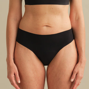 Model trägt ooia Inkontinenz Slip in schwarz in nahtlosem Design.
frontal