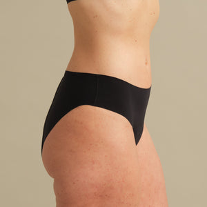 Model trägt ooia Inkontinenz Slip in schwarz in nahtlosem Design.
seitlich