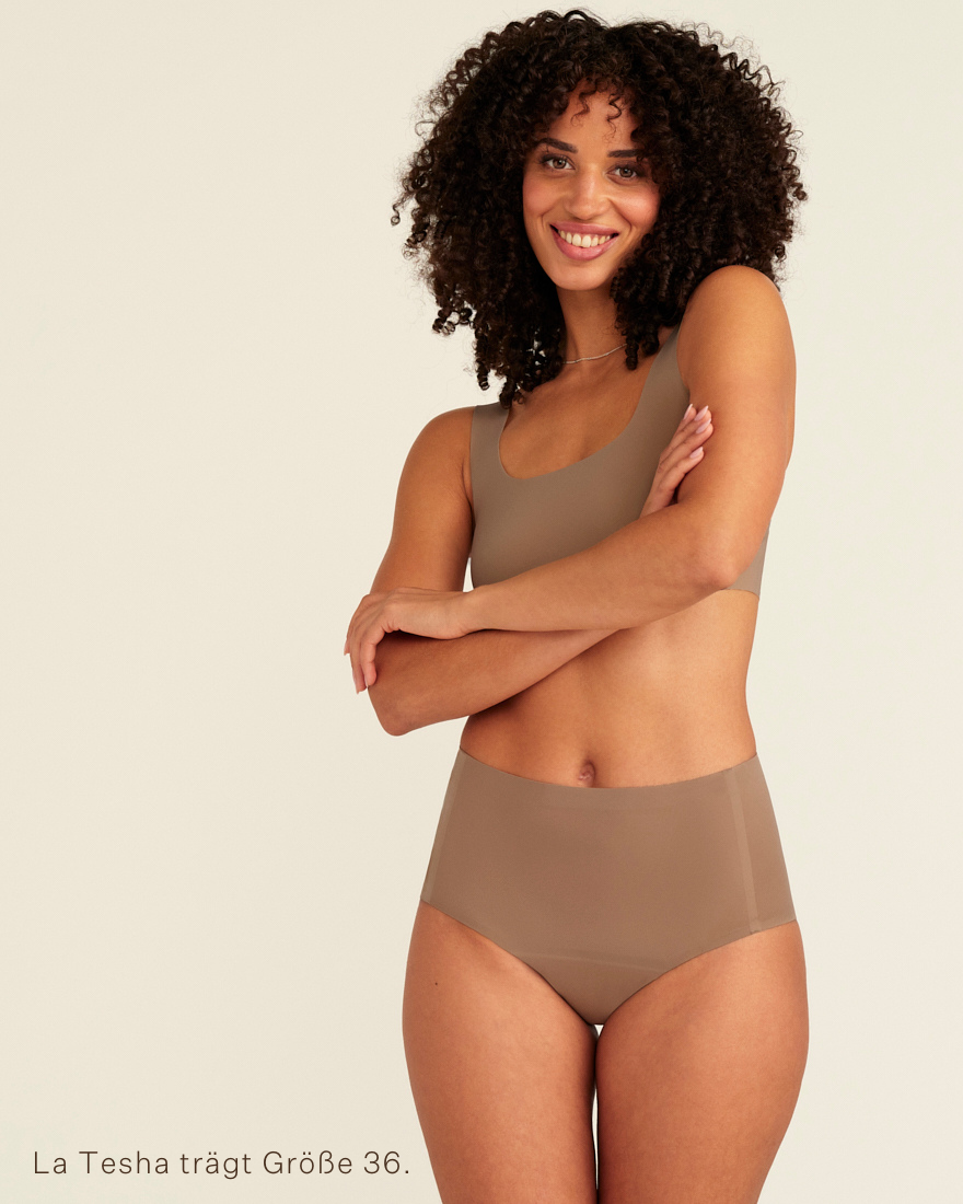 Modell trägt ooia Periodenunterwäsche Highwaist Seamless in Taupe mit hohem Bund und nahtlosem Design