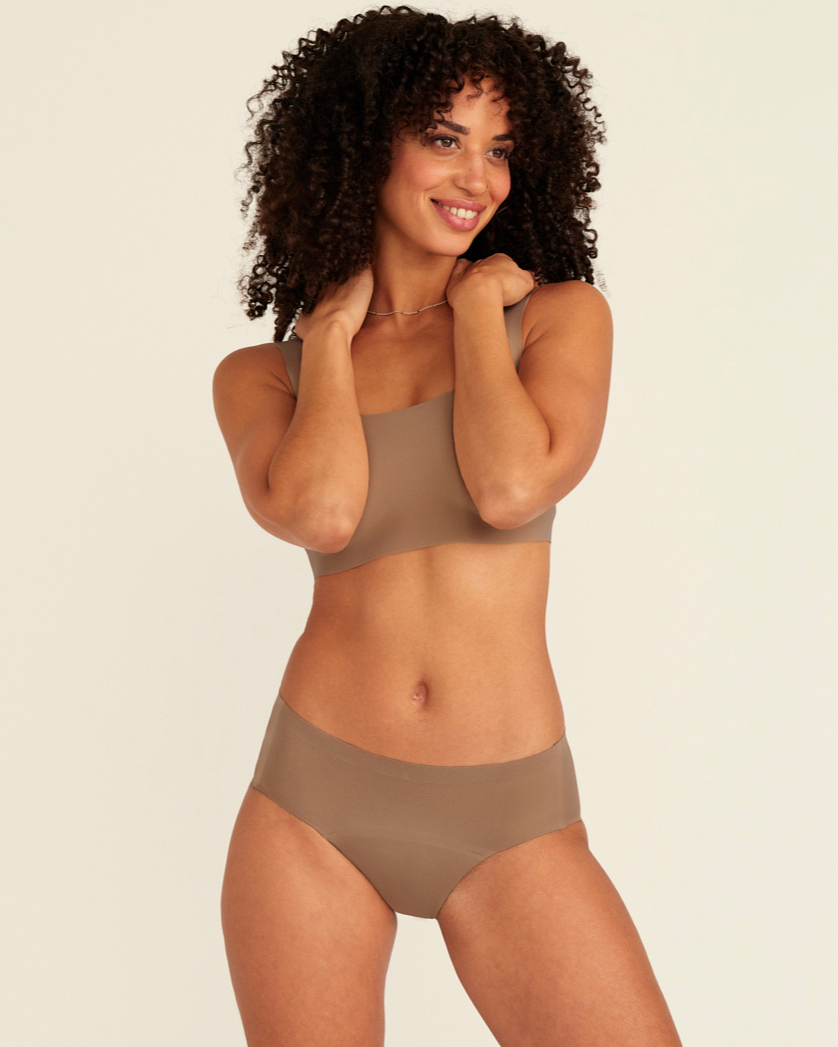 Modell trägt ooia Periodenunterwäsche Hipster Seamless in Taupe mit nahtlosem Design