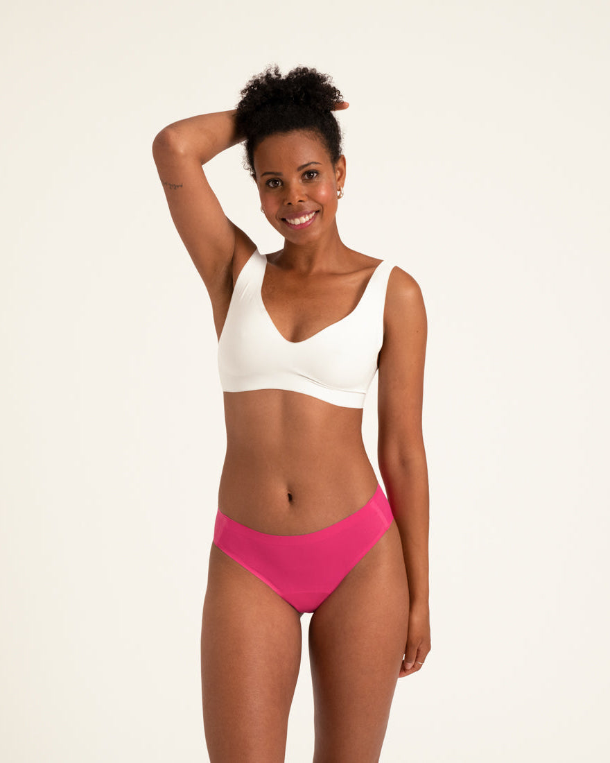 Model trägt ooia Menstruationsunterwäsche Slip Seamless in hot pink im nahtlosen Design.