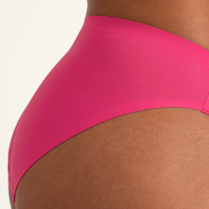 Model trägt ooia Periodenunterwäsche Slip Seamless in hot pink im nahtlosen Design. Keine Naht.