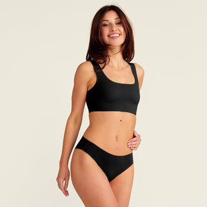 Modell trägt ooia everyday Slip Seamless in Schwarz – nahtlose Unterwäsche, die Slipeinlagen ersetzt.