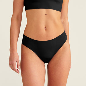 Modell trägt ooia everyday Slip Seamless in Schwarz – nahtlose Unterwäsche, die Slipeinlagen ersetzt.