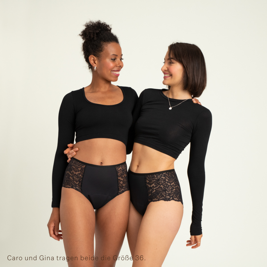 Zwei Models tragen ooia Highwaist Lace Extra Strong in Schwarz – elegante Periodenunterwäsche mit hohem Spitzenbund und Spitzeneinsätzen.