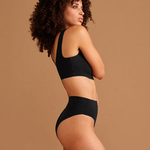 Modell trägt ooia Highwaist Seamless Cheeky in Schwarz – nahtloser Slip mit hoher Taille