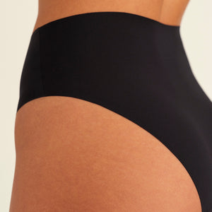 Modell trägt ooia Highwaist Seamless Cheeky in Schwarz – nahtloser Slip mit hoher Taille und Beinausschnitt, Detailansicht nahtloses Design