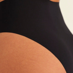 Modell trägt ooia Highwaist Seamless Cheeky in Schwarz – nahtloser Slip mit hoher Taille und Beinausschnitt, Detailansicht nahtloses Design