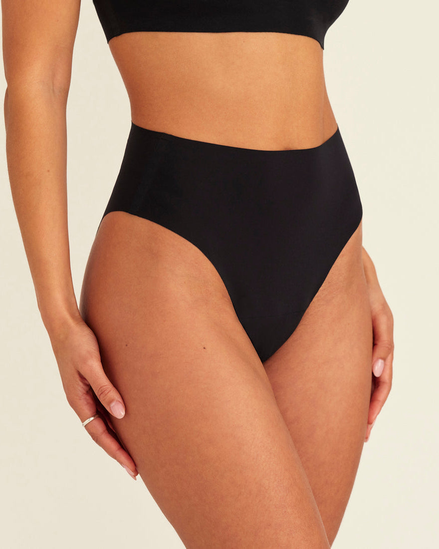 Modell trägt ooia Highwaist Seamless Cheeky in Schwarz – nahtloser Slip mit hoher Taille und Beinausschnitt