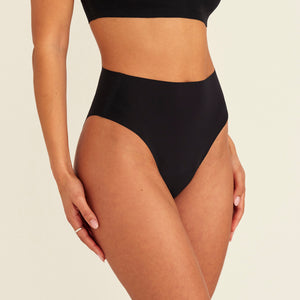 Modell trägt ooia Highwaist Seamless Cheeky in Schwarz – nahtloser Slip mit hoher Taille und Beinausschnitt