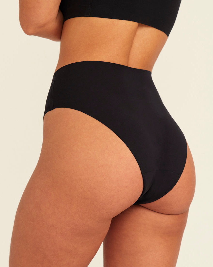 Modell trägt ooia Highwaist Seamless Cheeky in Schwarz – nahtloser Slip mit hoher Taille und Beinausschnitt, Rückansicht