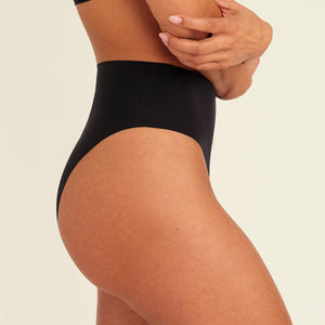 Modell trägt ooia Highwaist Seamless Cheeky in Schwarz – nahtloser Slip mit hoher Taille und Beinausschnitt