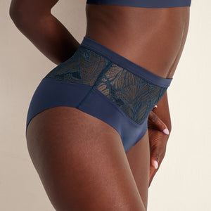 Modell trägt Periodenunterwäsche Highwaist Seamless Lace extra stark in dunkelblau mit nahtlosem Design mit breiter Spitze am Bund.
Frontal - Seite