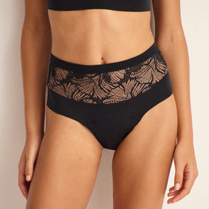 Modell trägt Periodenunterwäsche Highwaist Seamless Lace extra stark in schwarz mit nahtlosem Design mit breiter Spitze am Bund.
Frontansicht, stehend