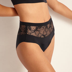Modell trägt Periodenunterwäsche Highwaist Seamless Lace extra stark in schwarz mit nahtlosem Design mit breiter Spitze am Bund.
Frontansicht, Nah
