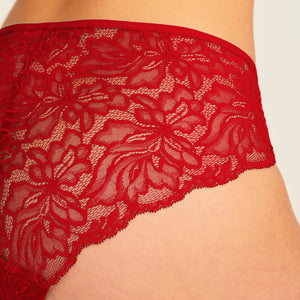 Modell trägt ooia Hipster Allover Lace in Rot – Periodenunterwäsche mit durchgehender Spitze. Detailansicht.
