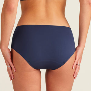 Modell trägt ooia Periodenunterwäsche Hipster Seamless Extra Strong in midnight mit nahtlosem Deign, Rückansicht