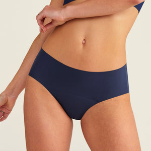 Modell trägt ooia Periodenunterwäsche Hipster Seamless Extra Strong in midnight mit nahtlosem Design
