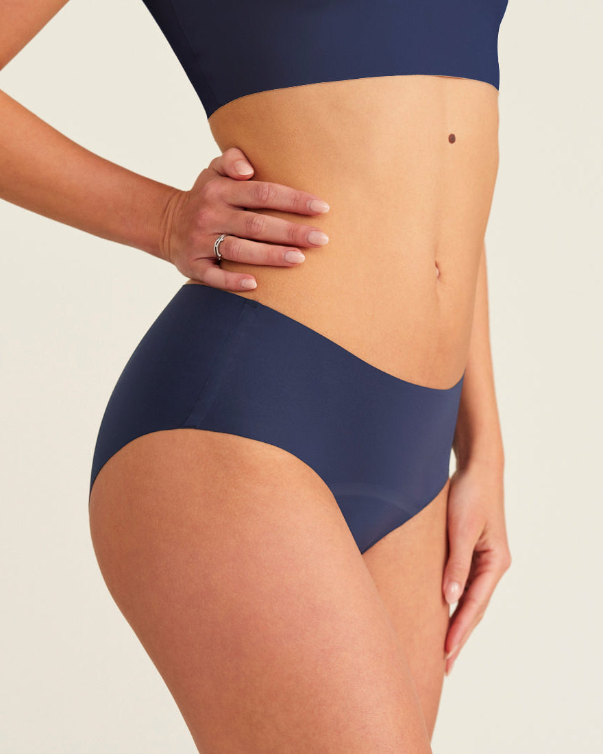 Modell trägt ooia Periodenunterwäsche Hipster Seamless Extra Strong in midnight mit nahtlosem Design