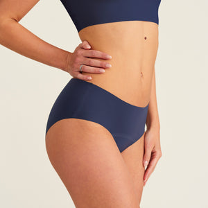Modell trägt ooia Periodenunterwäsche Hipster Seamless Extra Strong in midnight mit nahtlosem Design