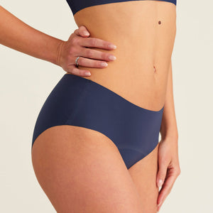 Modell trägt ooia Periodenunterwäsche Hipster Seamless Extra Strong in midnight mit nahtlosem Design