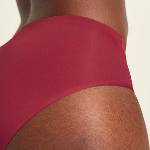 Modell trägt Hipster Seamless in Merlot - nahtlose Periodenunterwäsche von ooia. Detailansicht.