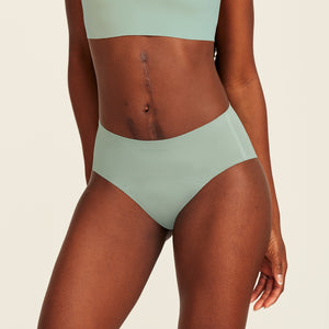 Modell trägt ooia Periodenunterwäsche Hipster Seamless in sage mit nahtlosem Design