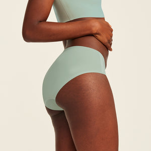 Modell trägt ooia Periodenunterwäsche Hipster Seamless in sage mit nahtlosem Design