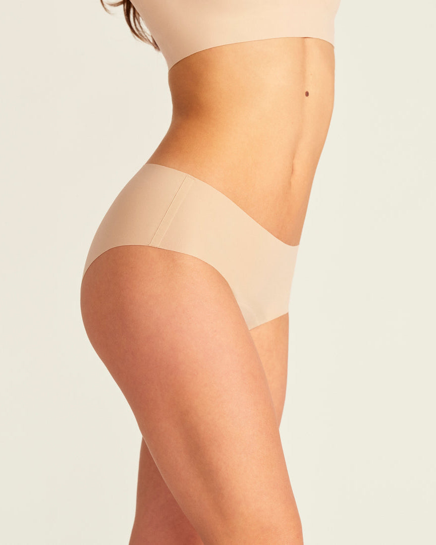 Modell trägt nahtlose ooia Periodenunterwäsche Hipster Seamless Extra Strong in beige.