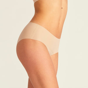 Modell trägt nahtlose ooia Periodenunterwäsche Hipster Seamless Extra Strong in beige.