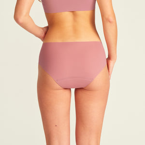 Modell trägt nahtlose ooia Periodenunterwäsche Hipster Seamless Extra Strong in dusky pink. Rückansicht.
