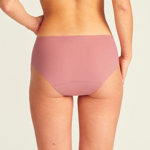Modell trägt nahtlose ooia Periodenunterwäsche Hipster Seamless Extra Strong in dusky pink. Rückansicht.