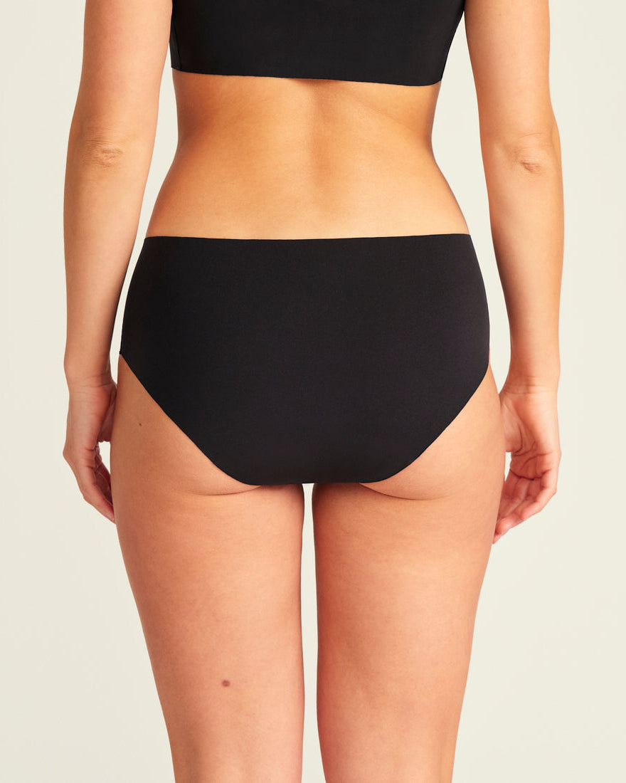 Modell trägt ooia Hipster Seamless Extra Strong in Schwarz – nahtlose Unterwäsche für eine starke Periode, Rückansicht
