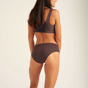 Modell trägt ooia Periodenunterwäsche Seamless Hipster in der Farbe Cocoa mit nahtlosem Design, Rüchansicht
