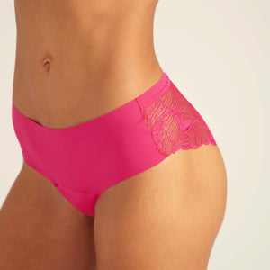 Modell trägt ooia Periodenunterwäsche Hipster Seamless Lace in hot pink, Detailaufnahme nahtlose Front und Spitze am Gesäß