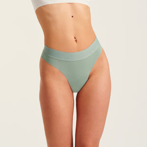 Modell trägt ooia Slip Seamless Cheeky in Sage – nahtlose Periodenunterwäsche mit hohem Beinausschnitt