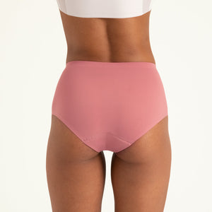 Modell trägt ooia Highwaist Seamless in Dusky Pink – nahtlose Periodenunterwäsche mit hohem Bund. Rückansicht.