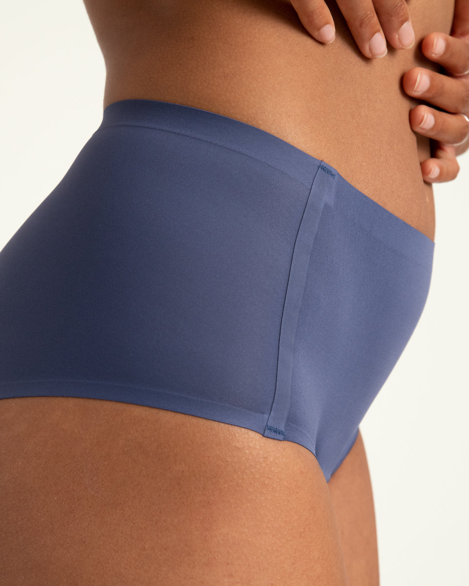 Modell trägt ooia Highwaist Seamless in Smoky Blue – nahtlose Periodenunterwäsche mit hohem Bund. Detailansicht.