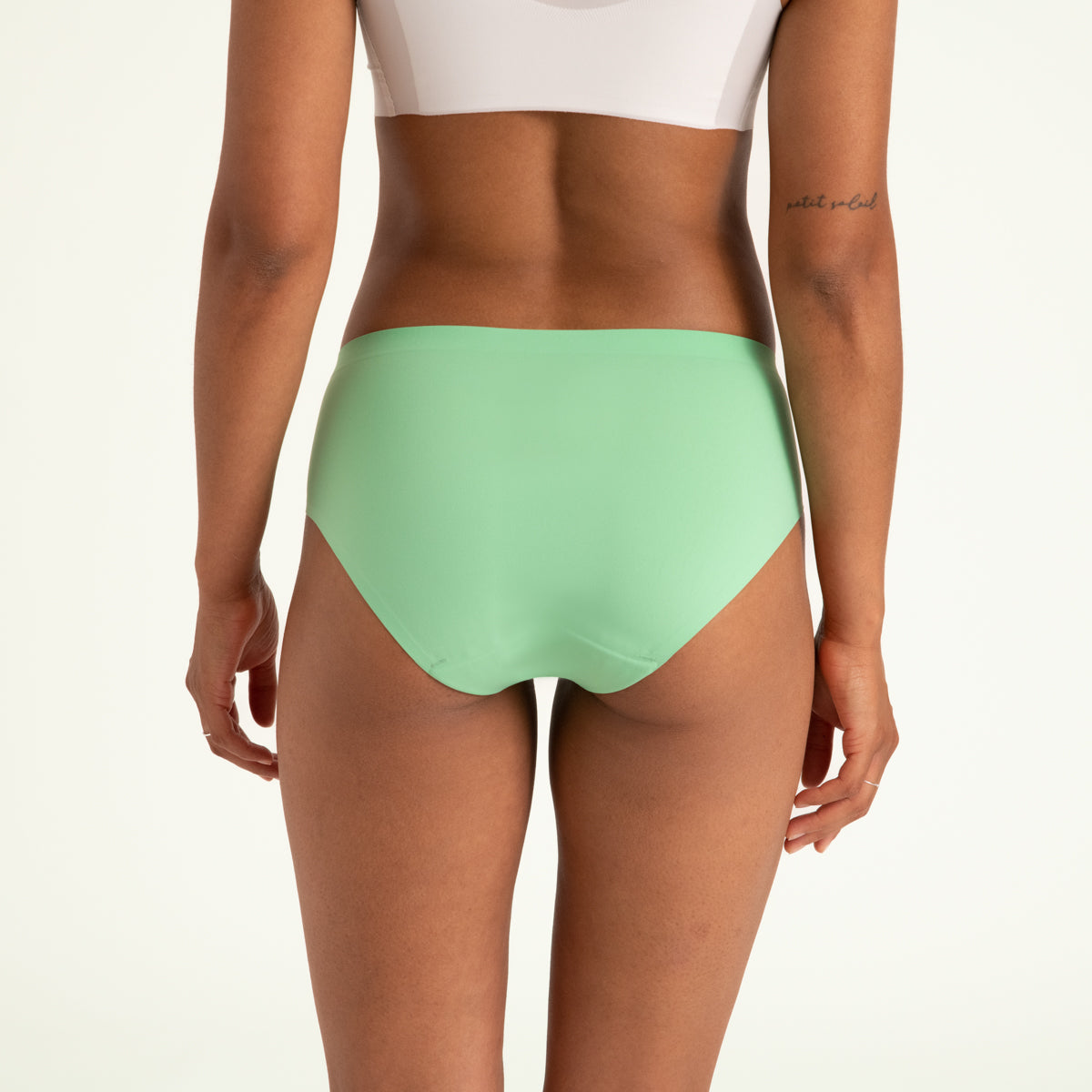 Modell trägt ooia Hipster Seamless in Bright Sage – Periodenunterwäsche mit bequemer Passform und weichem, nahtlosem Stoff. Rückansicht.