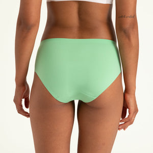 Modell trägt ooia Hipster Seamless in Bright Sage – Periodenunterwäsche mit bequemer Passform und weichem, nahtlosem Stoff. Rückansicht.