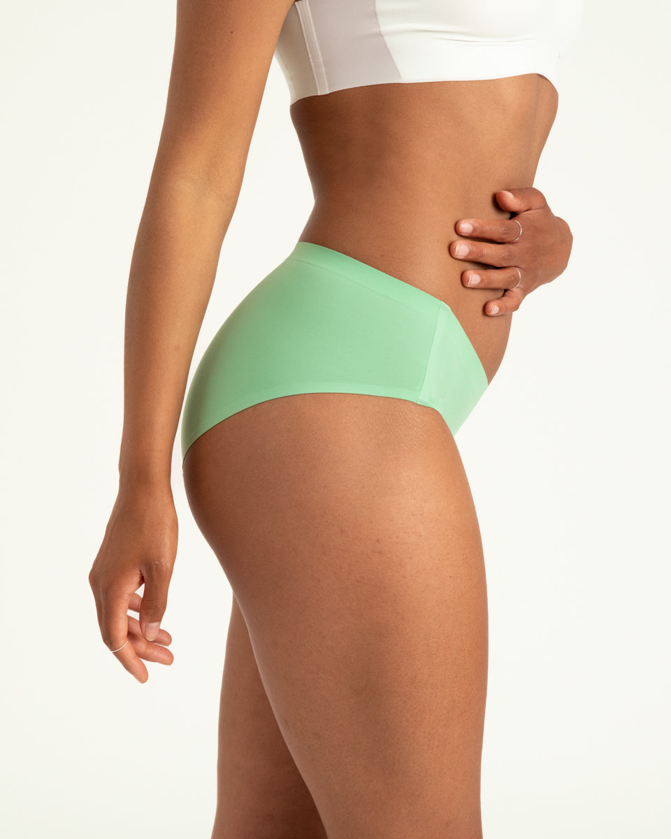 Modell trägt ooia Hipster Seamless in Bright Sage – Periodenunterwäsche mit bequemer Passform und weichem, nahtlosem Stoff